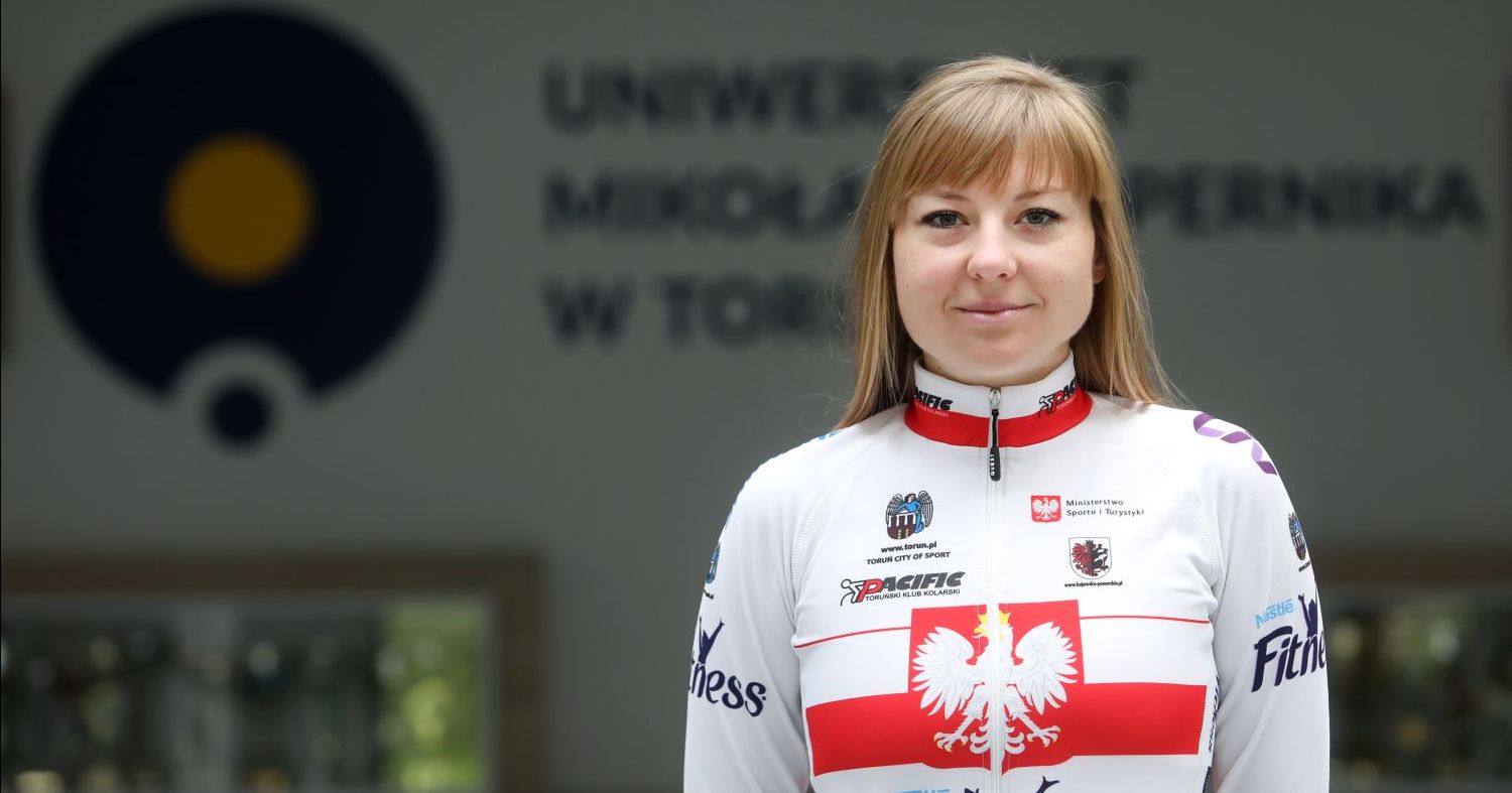 Karolina Karasiewicz Karolina Karasiewicz, młoda kobieta pozująca do zdjęcia w sportowym stroju kolarskim z flagą i godłem Polski